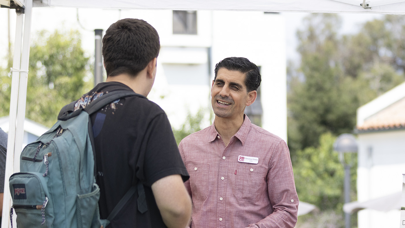 Student receiving information about DSPS programs from Basic Needs Resource Fair